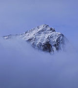 Mountain peak glimpsed through the clouds.